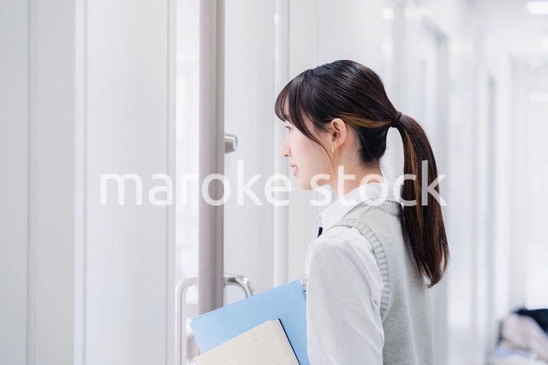 教材を持って校内を歩く女子高生