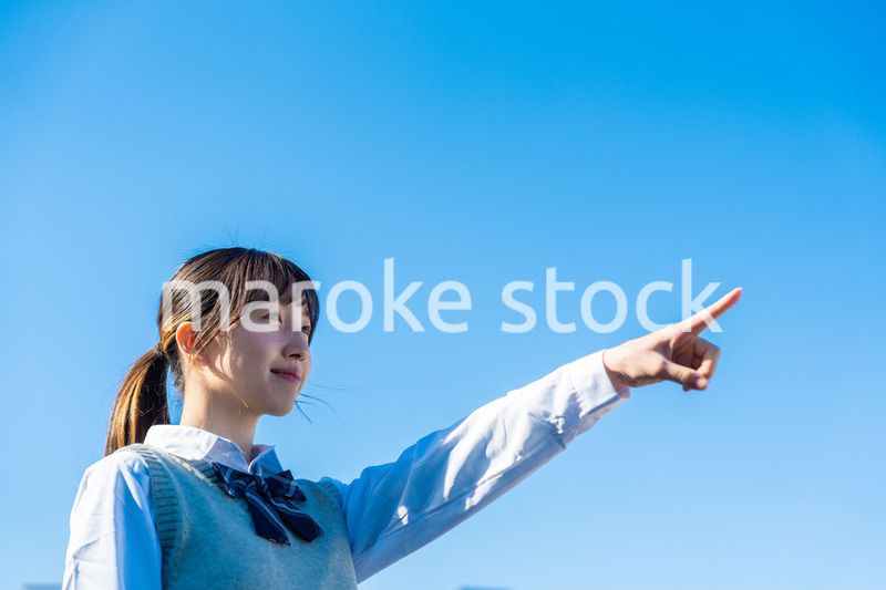 制服で上を指差す女子高生