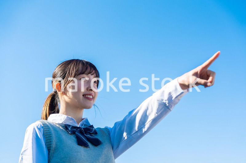 制服で上を指差す女子高生