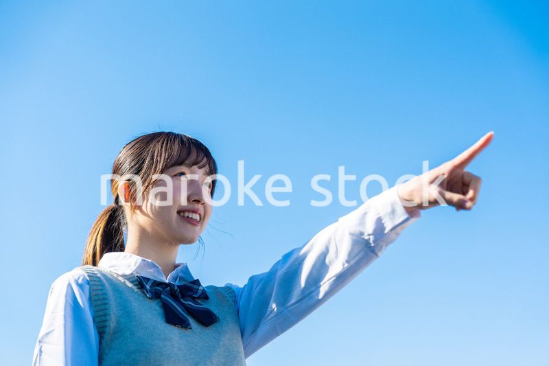 制服で上を指差す女子高生