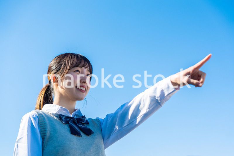 制服で上を指差す女子高生