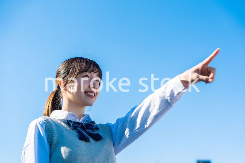 制服で上を指差す女子高生