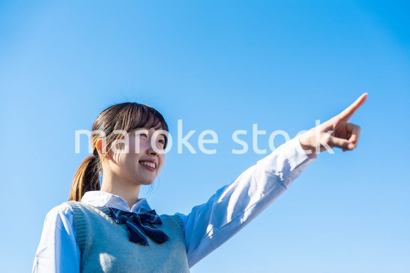 制服で上を指差す女子高生
