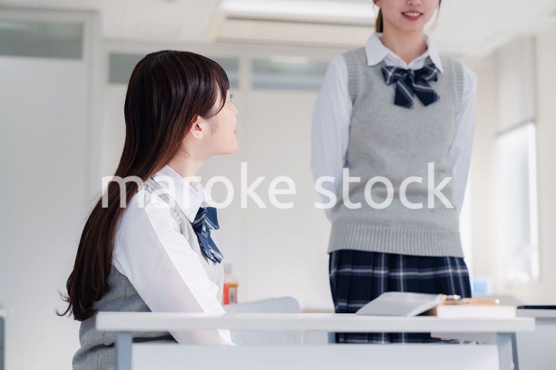 教室で休み時間に話す女子高生