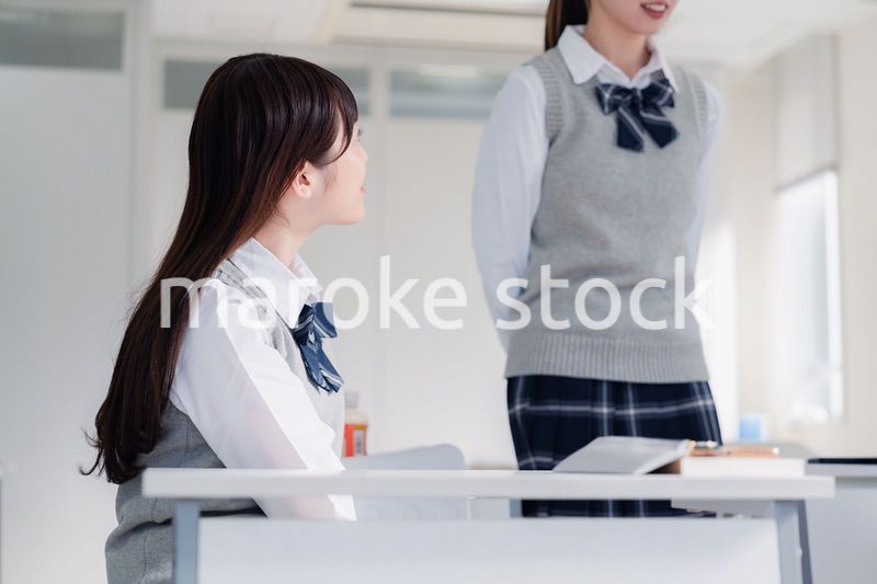 教室で休み時間に話す女子高生