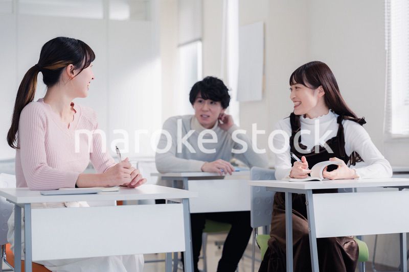 キャンパスで仲良く話をする大学生