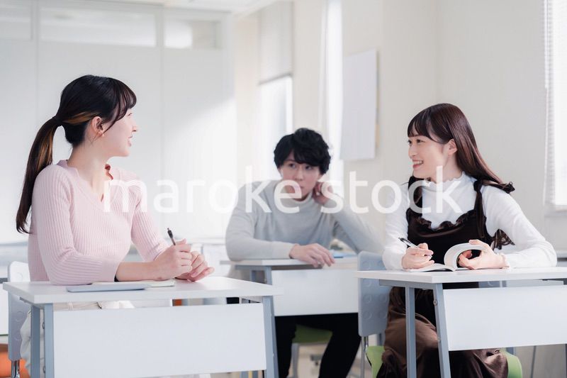 キャンパスで仲良く話をする大学生