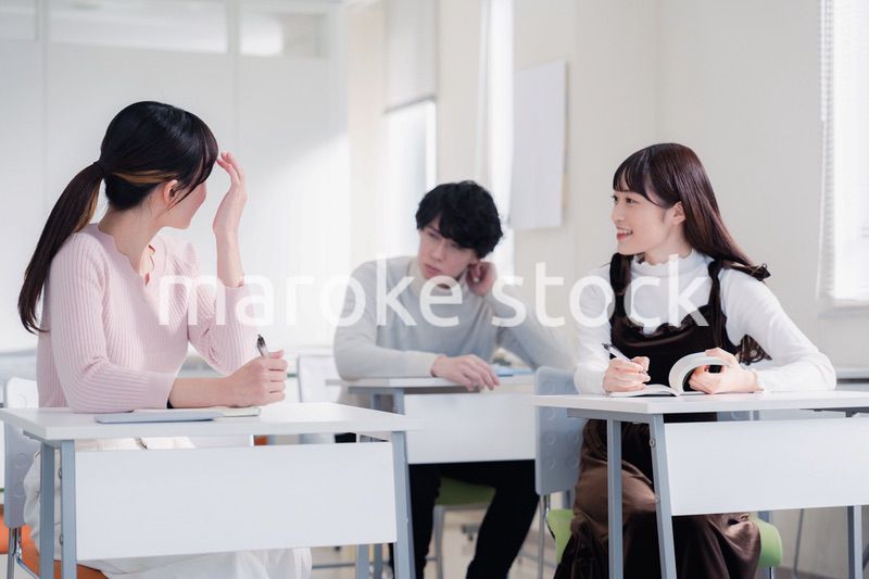 キャンパスで仲良く話をする大学生