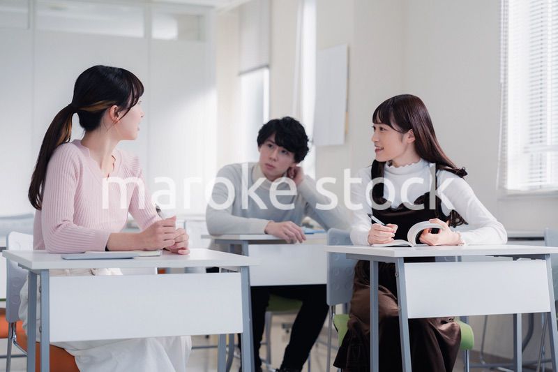 キャンパスで仲良く話をする大学生