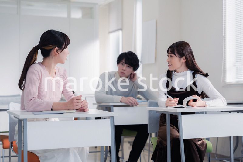 キャンパスで仲良く話をする大学生