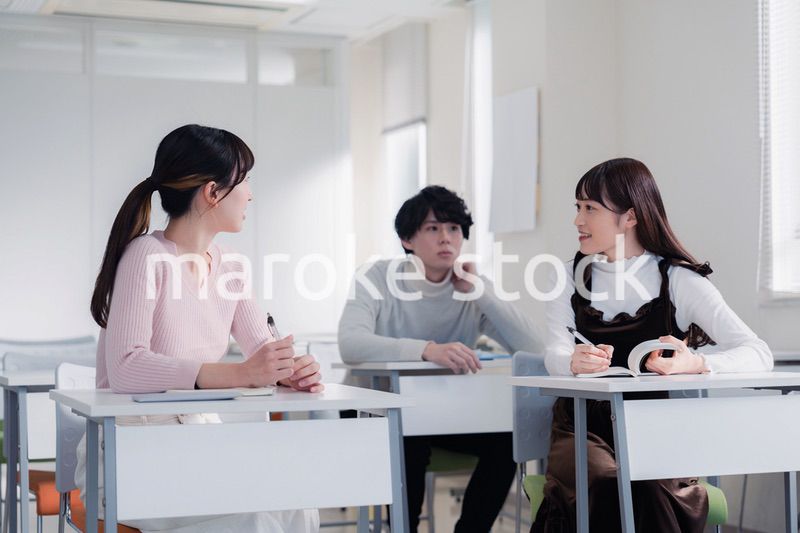 キャンパスで仲良く話をする大学生