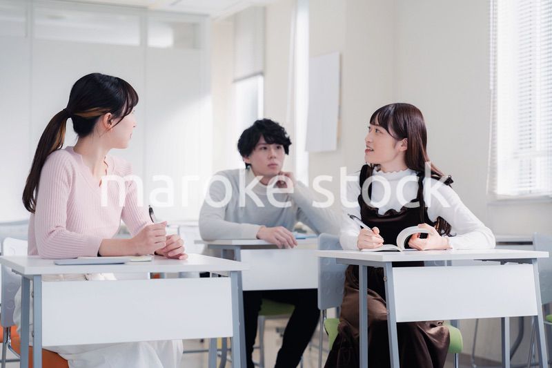 キャンパスで仲良く話をする大学生