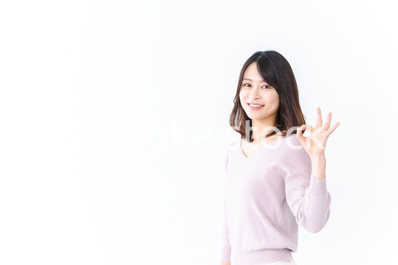 笑顔でグッドサインを示す若い女性