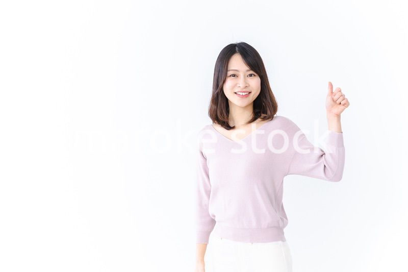 笑顔でグッドサインを示す若い女性