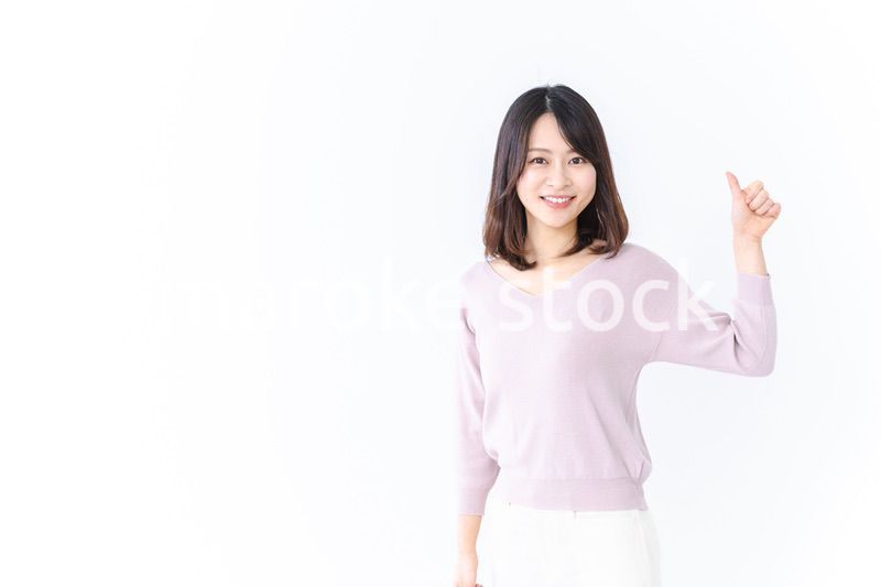 笑顔でグッドサインを示す若い女性