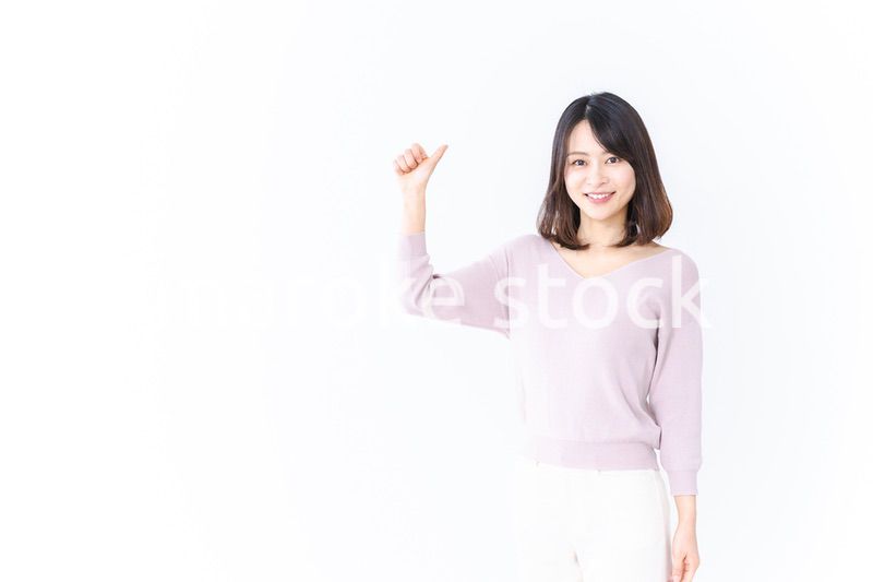 笑顔でグッドサインを示す若い女性