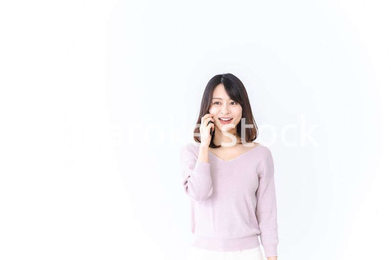 笑顔で電話をかける若い女性