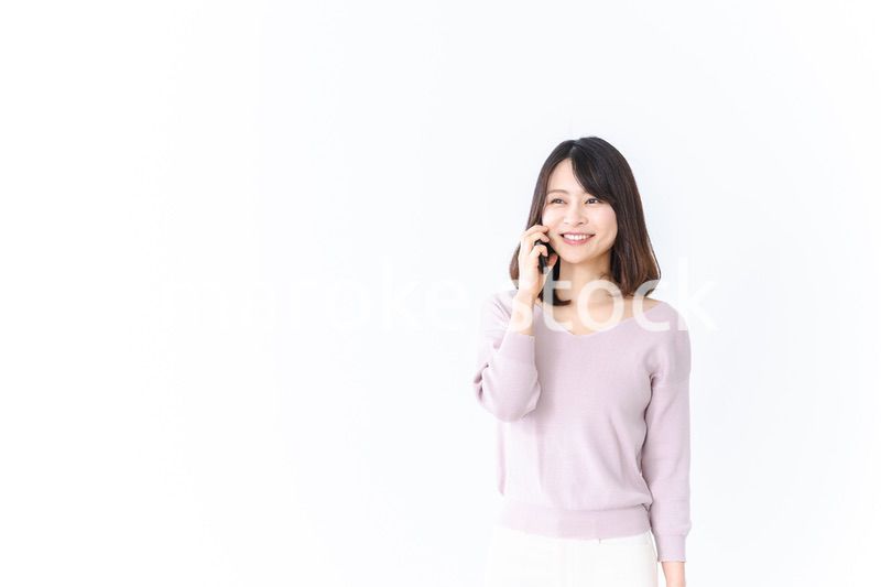 笑顔で電話をかける若い女性