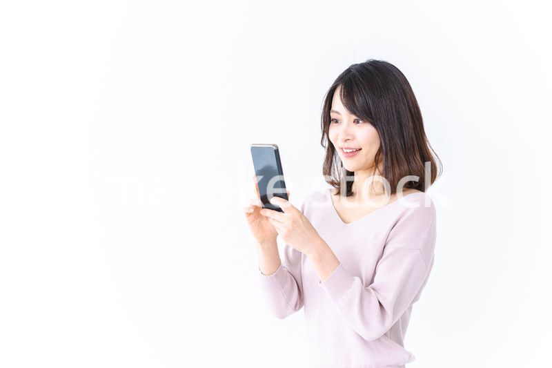 笑顔でスマホを使う若い女性