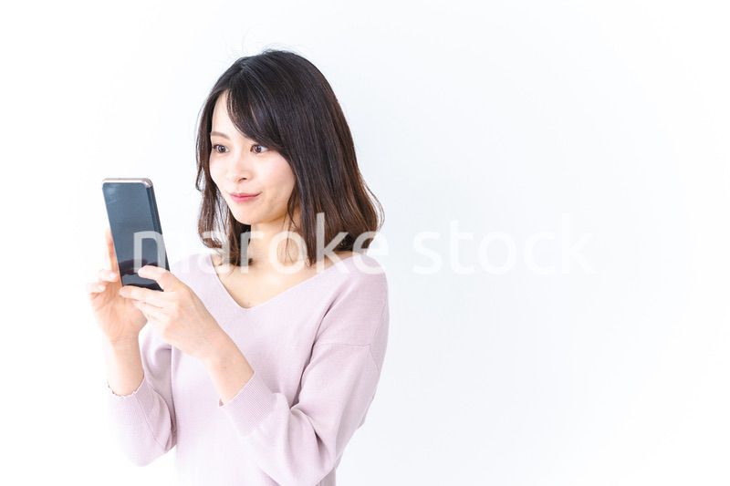 笑顔でスマホを使う若い女性