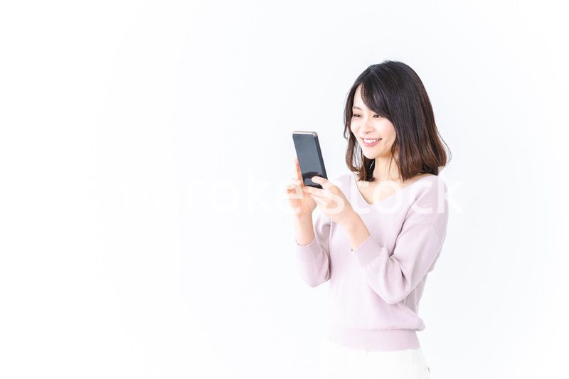 笑顔でスマホを使う若い女性