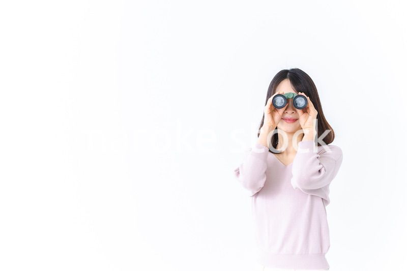 双眼鏡で遠くを見る若い女性