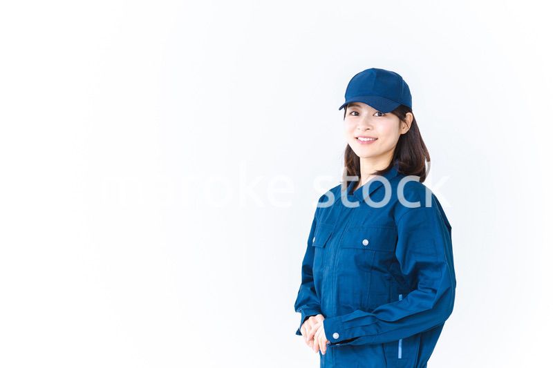 作業服を来て笑顔で仕事をする若い女性