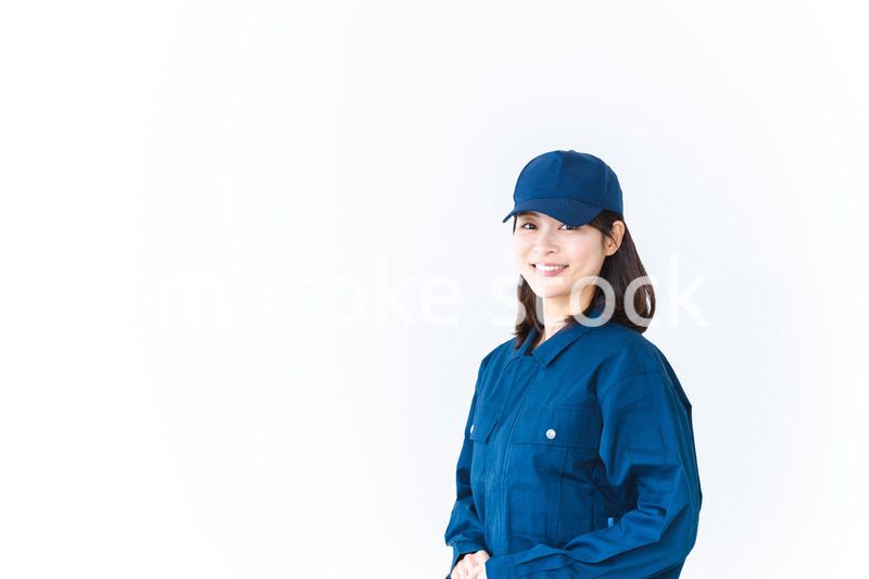 作業服を来て笑顔で仕事をする若い女性