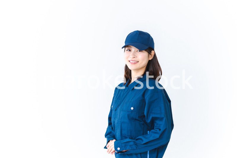 作業服を来て笑顔で仕事をする若い女性