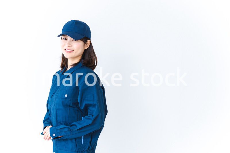 作業服を来て笑顔で仕事をする若い女性