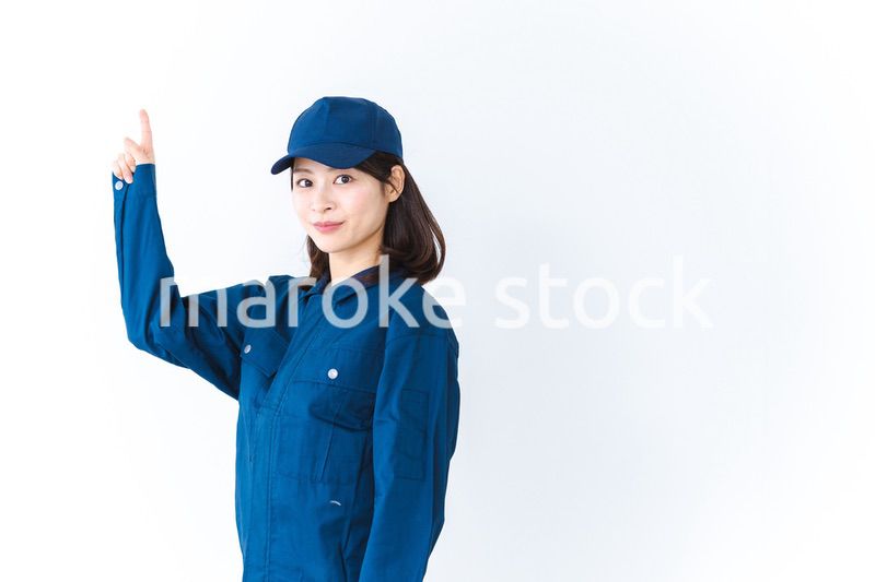 作業服を着て笑顔で指差す若い女性