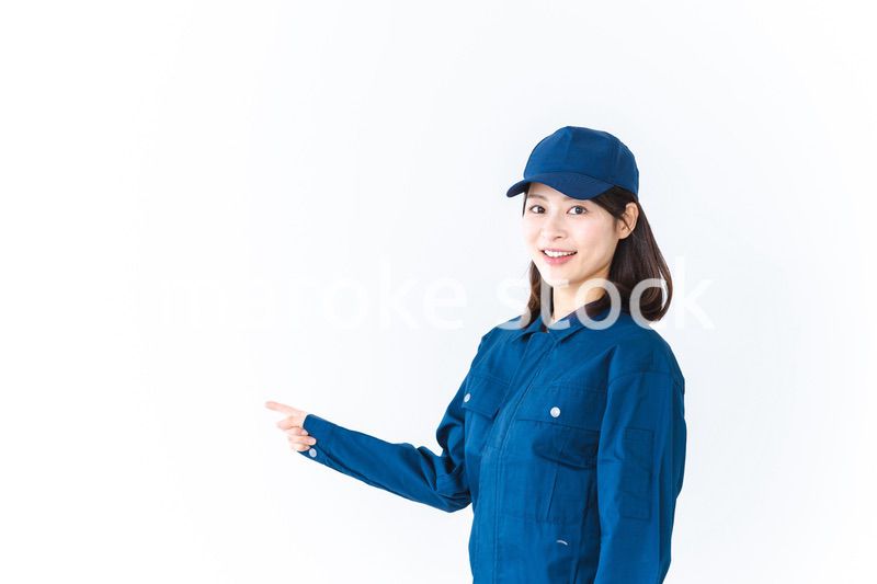 作業服を着て笑顔で指差す若い女性