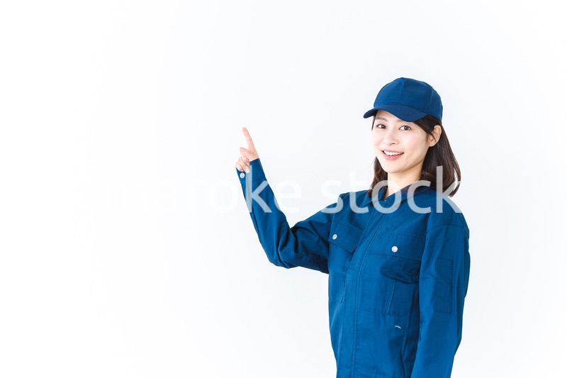 作業服を着て笑顔で指差す若い女性
