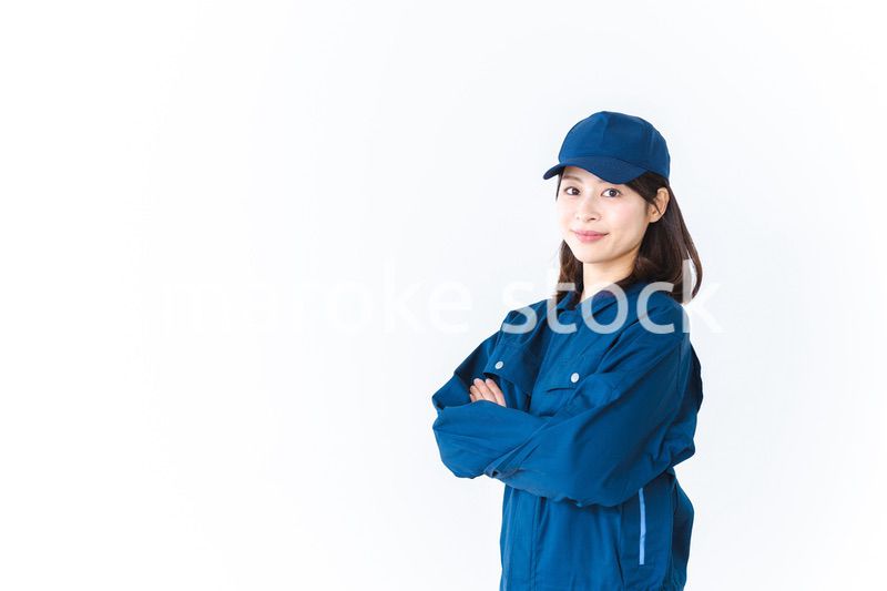 作業服を来て笑顔で仕事をする若い女性