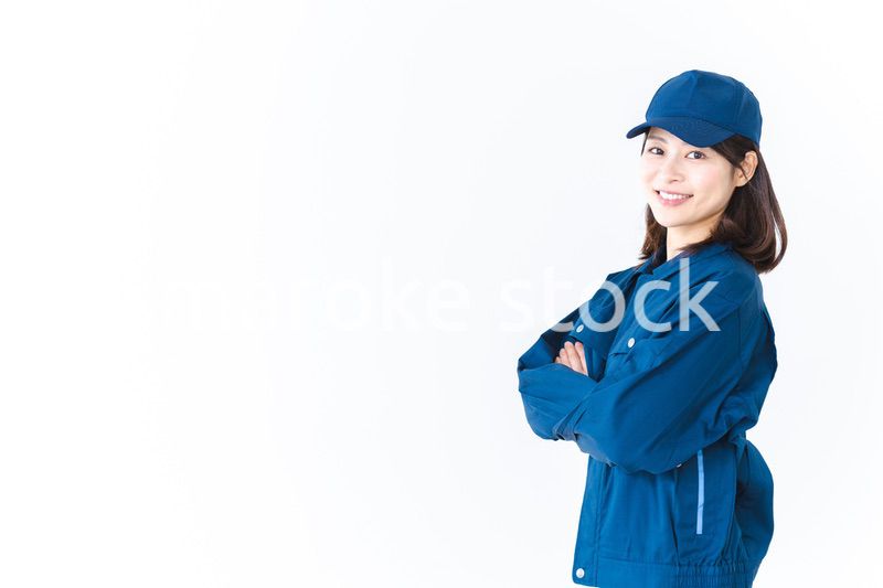 作業服を来て笑顔で仕事をする若い女性