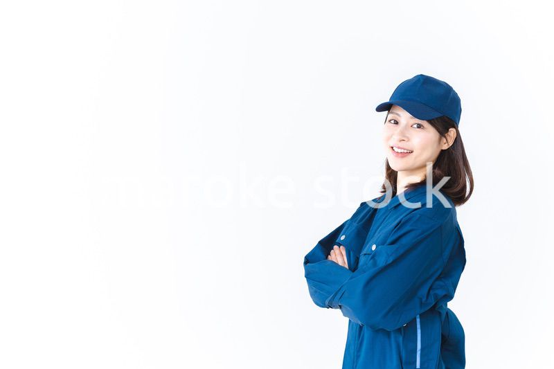作業服を来て笑顔で仕事をする若い女性