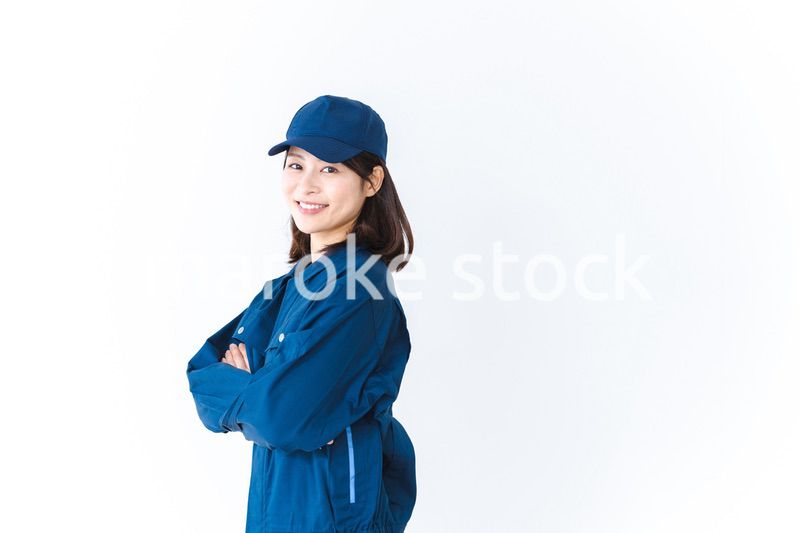 作業服を来て笑顔で仕事をする若い女性