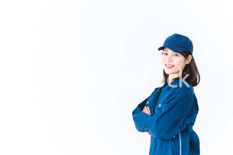 作業服を来て笑顔で仕事をする若い女性