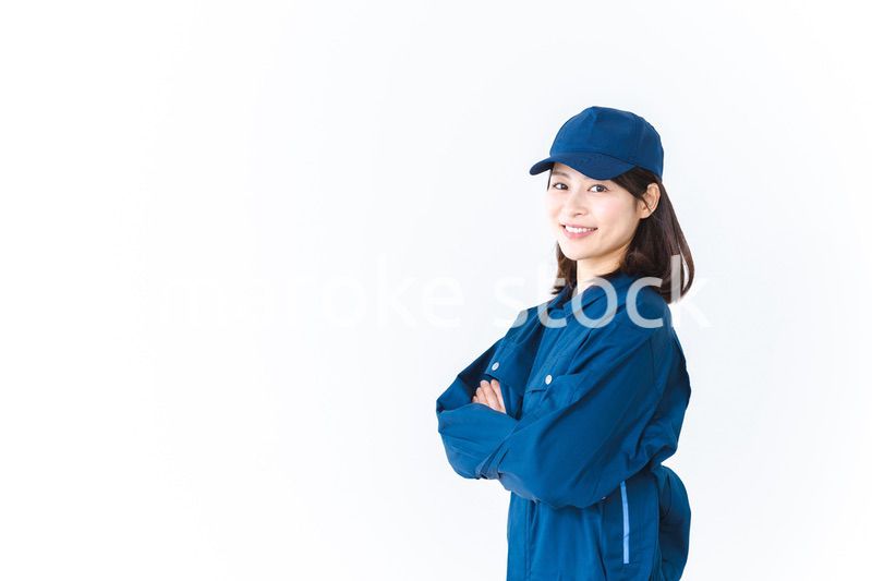 作業服を来て笑顔で仕事をする若い女性