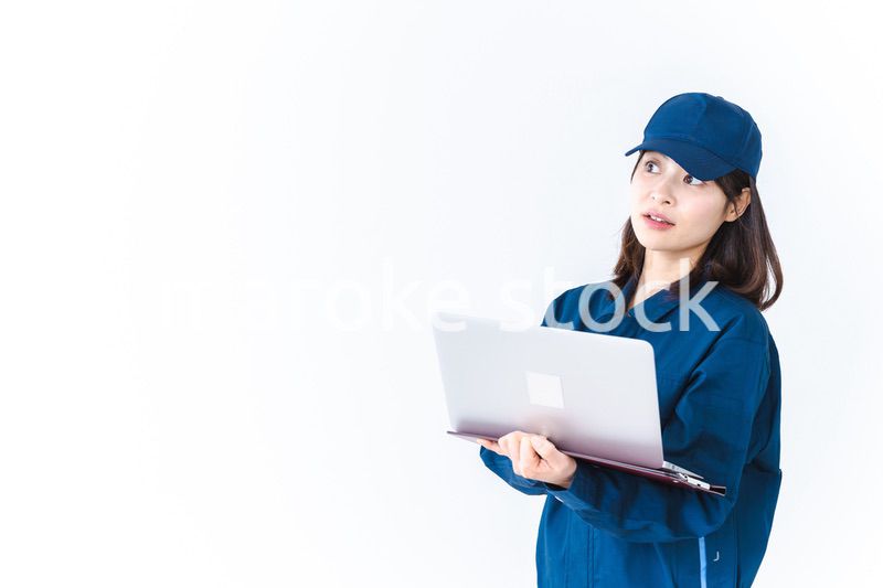 作業服でパソコンを使う若い女性