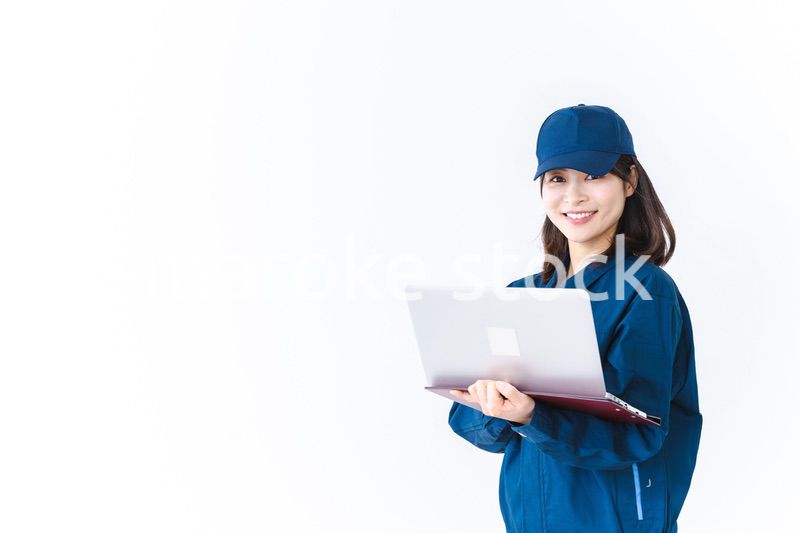 作業服でパソコンを使う若い女性