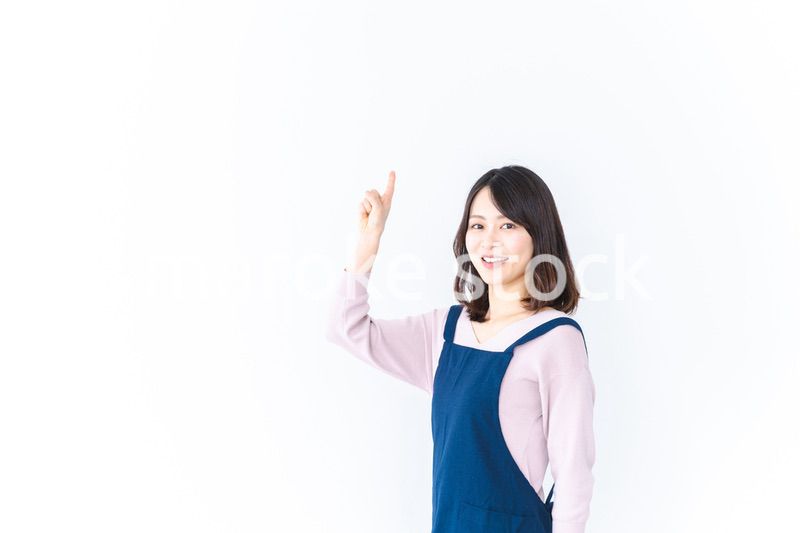 エプロンを着ておすすめを示す若い女性