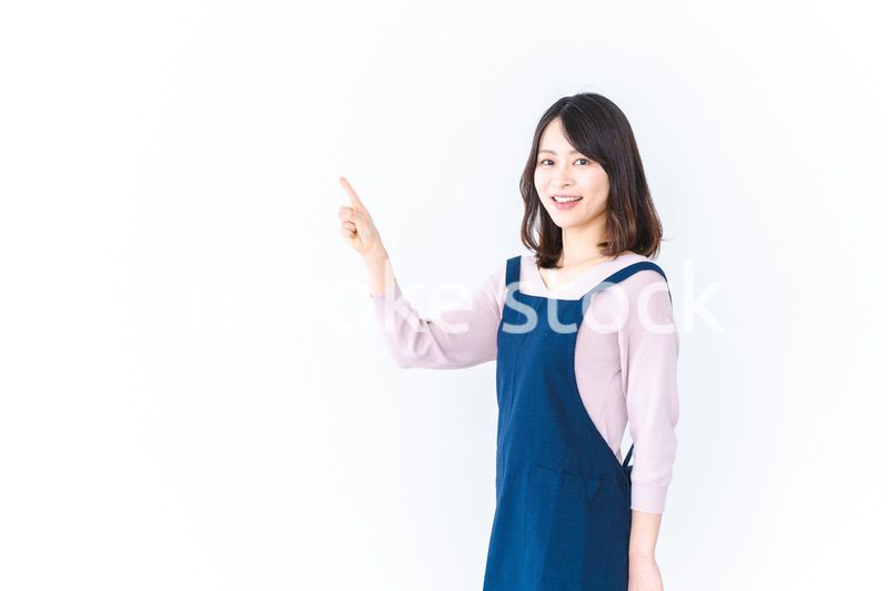 エプロンを着ておすすめを示す若い女性
