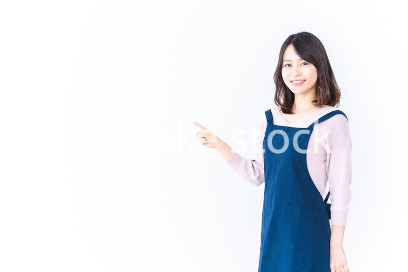 エプロンを着ておすすめを示す若い女性