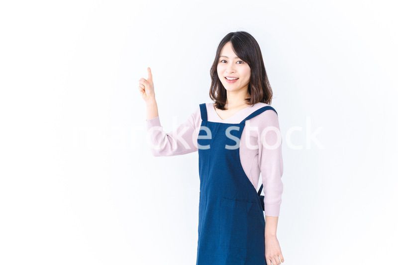 エプロンを着ておすすめを示す若い女性