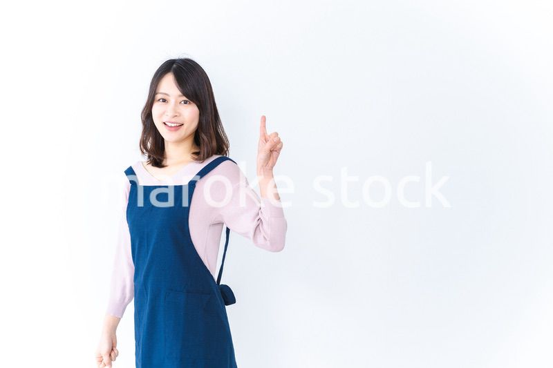 エプロンを着ておすすめを示す若い女性