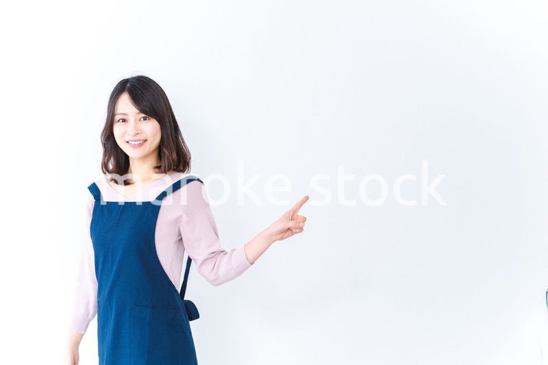 エプロンを着ておすすめを示す若い女性