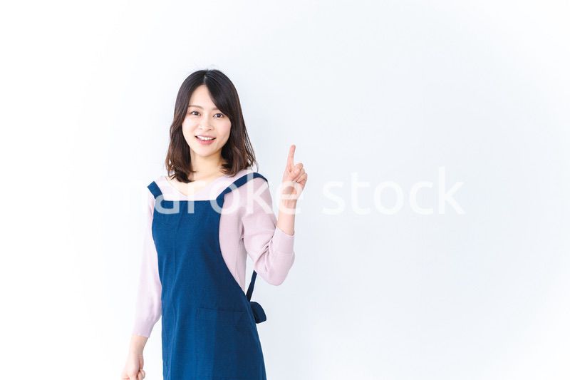 エプロンを着ておすすめを示す若い女性