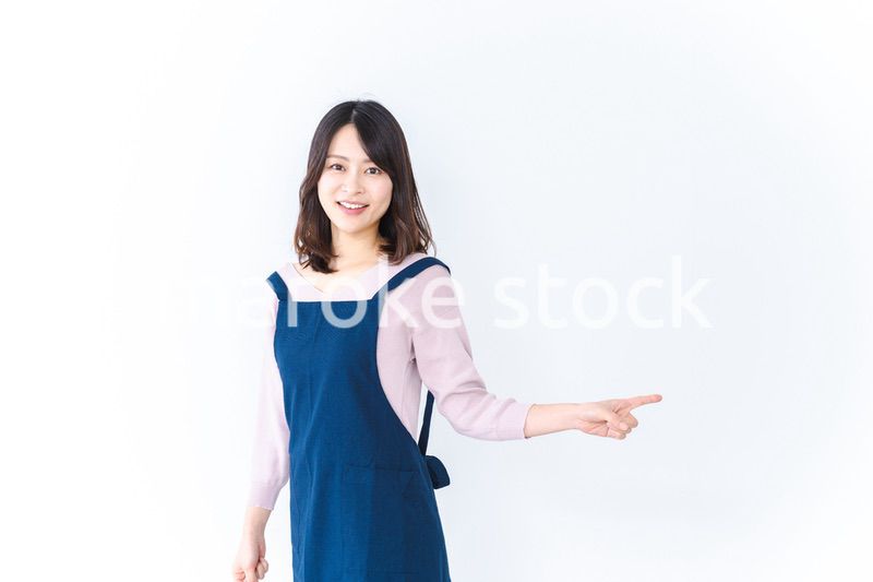 エプロンを着ておすすめを示す若い女性