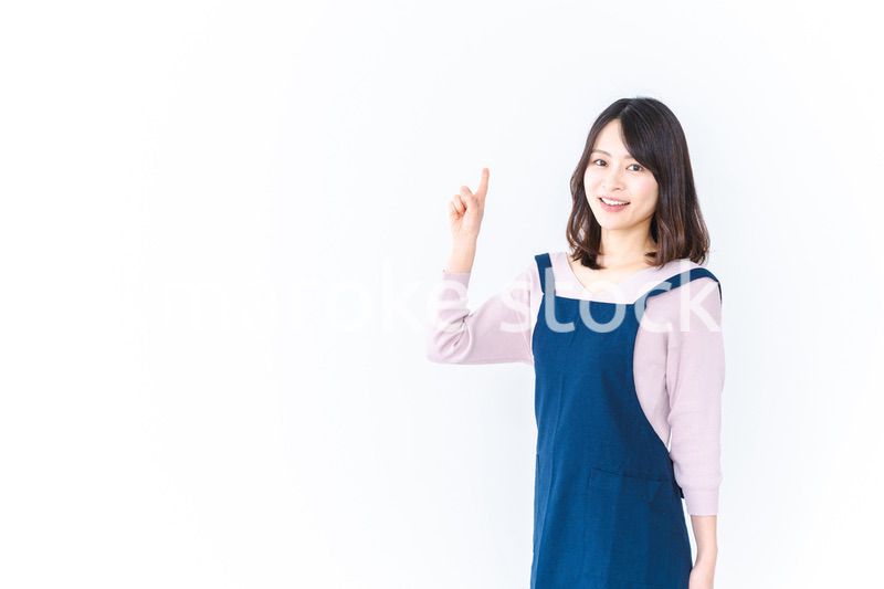 エプロンを着ておすすめを示す若い女性